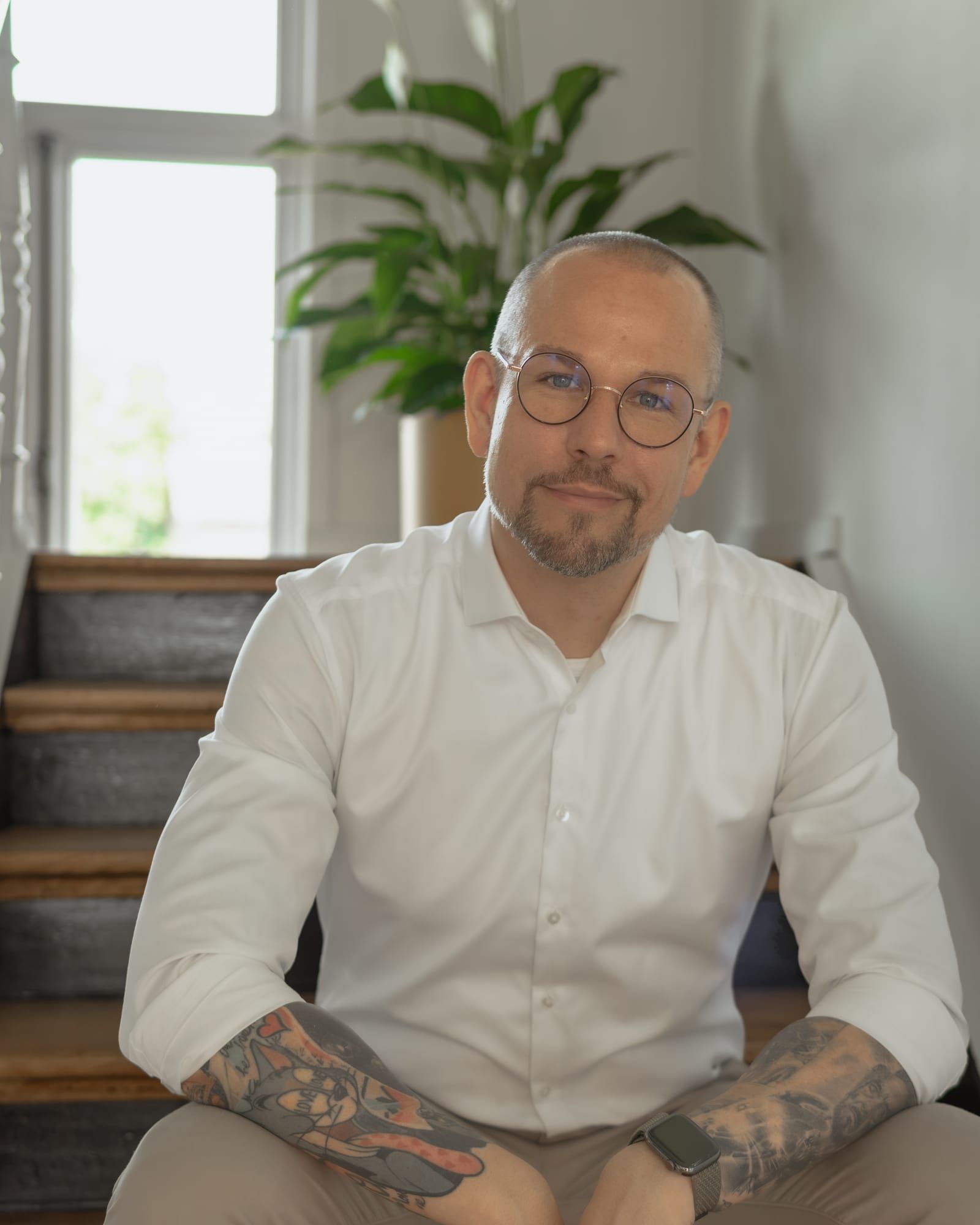 Andreas Lippke sitzt auf der Treppe im Büro in Wolfsburg.